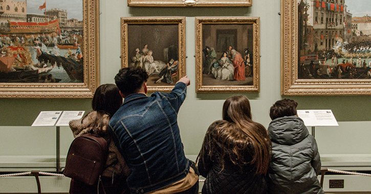 family of four admiring paintings inside The Bowes Museum